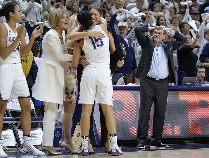 UConn players, coaches celebrate as time expires Monday in Storrs, Conn. The Huskies held on to defeat No. 6 South Carolina 66-55 to win their 100th-straight game. (Jessica Hill/Associated Press)