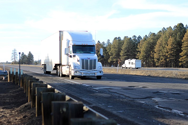 Semi-trucks stay in the left lane of Interstate 40 near Parks in an effort to dodge potholes. Numerous vehicles have been damaged by the potholes that are prevalent this winter across northern Arizona. 