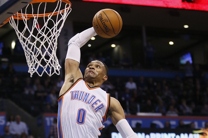 Oklahoma City Thunder guard Russell Westbrook (0) goes up for a dunk in front of New York Knicks forward Kristaps Porzingis (6) in the fourth quarter Feb. 15 in Oklahoma City. Oklahoma City won 116-105. (Sue Ogrocki/Associated Press)