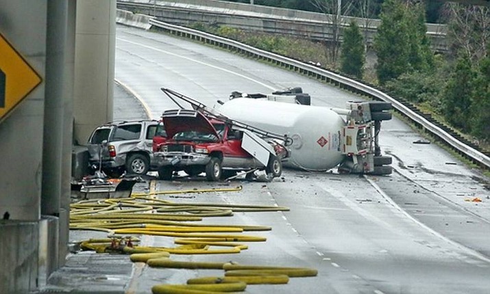A tanker truck carrying butane lays overturned Monday in Seattle. A taco truck that became stranded in the massive traffic jam came to the rescue of hungry drivers by opening up and serving lunch on the interstate.