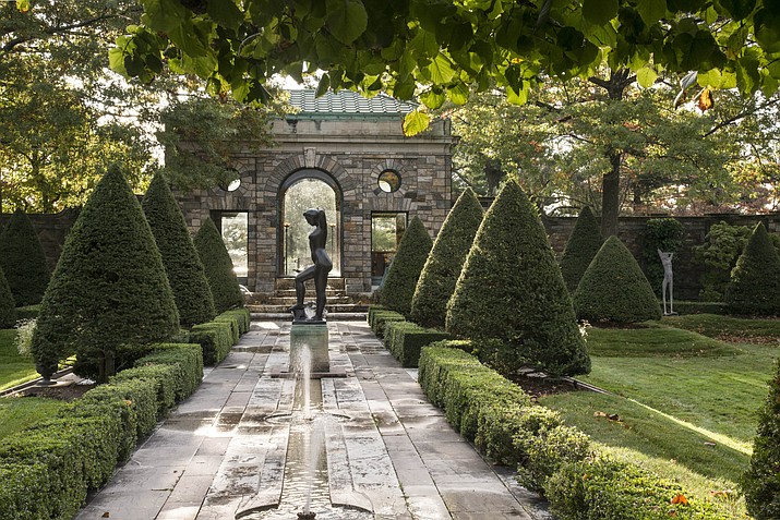 This undated photo provided by The Monacelli Press shows the Inner Garden at Kykuit, the country retreat established by John D. Rockefeller in Sleepy Hollow, N.Y. In this photo Aristide Maillol's "Bather Putting Up Her Hair" is silhouetted by the light of the Morning Garden beyond the teahouse. Maillol's Torso is juxtaposed with an Etruscan oil jar. The photo is featured in the book "The Rockefeller Family Gardens: An American Legacy." (Larry Lederman/The Monacelli Press via AP)