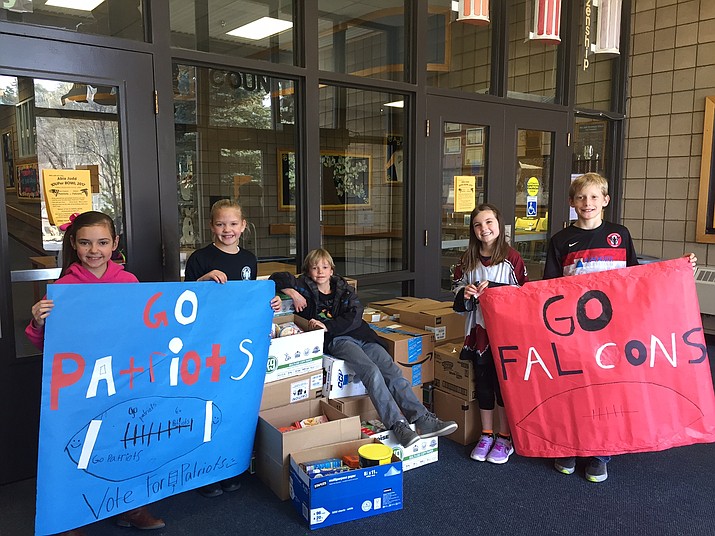 From left, fourth-grade Abia Judd students Sophia Davis, Reece Corlett, Mark Dunkel, Rylee Hobson and Cooper Kasun Clarstand with the 757 cans they boxed for the Yavapai Food Bank. 