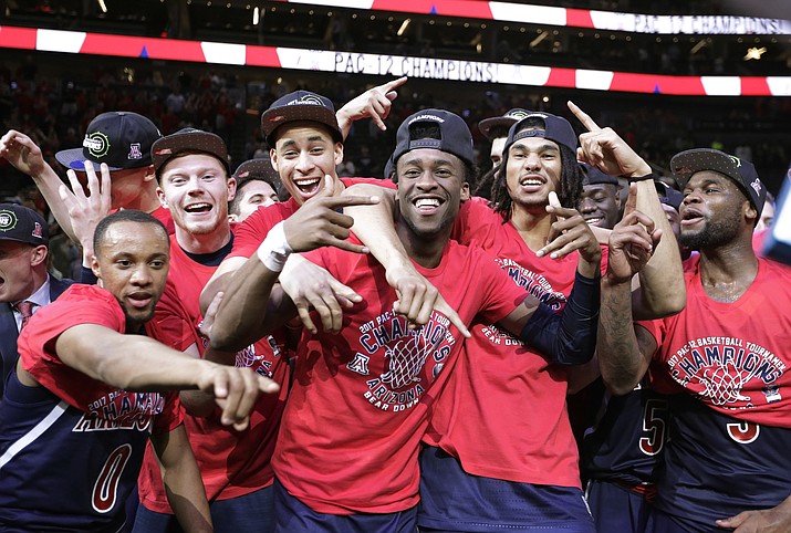 Arizona players celebrate as they pose for photographers after defeating Oregon 83-80 in an NCAA college basketball game for the championship of the Pac-12 men’s tournament Saturday, March 11, in Las Vegas.