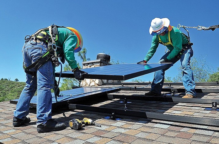 Edgar Soto and Juan Jamoa with SolarCity install solar panels on the roof of a home south of Prescott in 2012. Part of Arizona Public Service’s 2016 request would do away with the solar buyback program and change the reimbursements.  