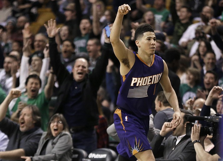 Phoenix Suns guard Devin Booker (1) gestures after he scored a basket as fans cheer him at TD Garden in the fourth quarter of an NBA basketball game against the Boston Celtics, Friday, March 24, in Boston. Booker scored 70 points, in their loss to the Celtics, 130-120. Booker is just the sixth player in NBA history to score 70 or more points in a game. (Elise Amendola/AP)