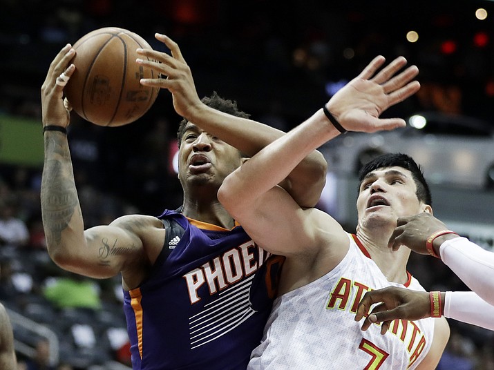 Phoenix Suns’ Marquese Chriss, left, grabs a rebound from Atlanta Hawks’ Ersan Ilyasova, of Turkey, in the second quarter Tuesday, March 28, in Atlanta. (David Goldman/AP)