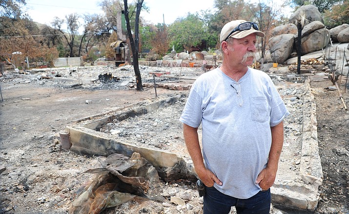 Les Stukenberg/The Daily Courier<br>Steve Keehner looks at some of his neighbors’ homes that burned during the Yarnell Hill fire. Keehner also lost his home, but he and his wife were able to escape with clothes and some important personal possessions.