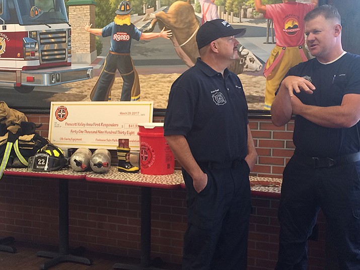 Mayer Fire District Chief Erik Kriwer (l) talks with Copper Canyon Fire & Medical Authority Captain Cory Ipson at Firehouse Subs on Tuesday, March 28 in front of the equipment granted to both the agencies as well as the Groom Creek Fire District by the Firehouse Subs Public Safety Foundation.