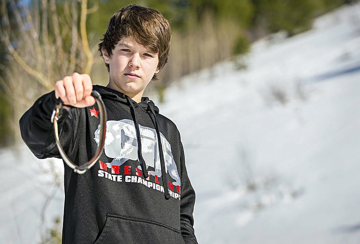 Canyon Mansfield, 14, holds the collar of his dog, Casey, who was killed March 16 by a M-44 cyanide-ejecting device placed on public land near his Pocatello, Idaho, home, by federal workers to kill coyotes.