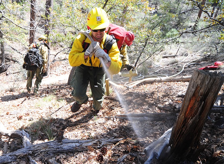 Prescott National Forest fire fighter Garrett Boone sprays a wet line around a simulated fire during the annual Basin OPs Drill near Goldwater Lake in Prescott.  (Les Stukenberg/Courier)