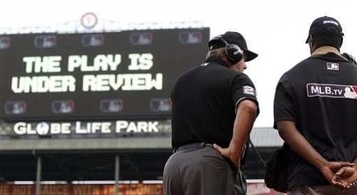 This May 16, 2015 file photo shows umpire Joe West (22) connecting with MLB’s review command center in New York. (Brandon Wade/AP, File)