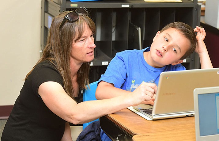 Third grade teacher Shelly Helmken helps Seth Vermilyea at Taylor Hicks Elementary School in Prescott Tuesday, May 2.  (Les Stukenberg/Courier)