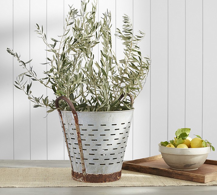 This undated photo provided by Pottery Barn shows their vintage Turkish olive harvesting pot which has character and style; fill it with an herb plant, or use it to store soaps or hand towels in a guest bath. (Pottery Barn via AP)
