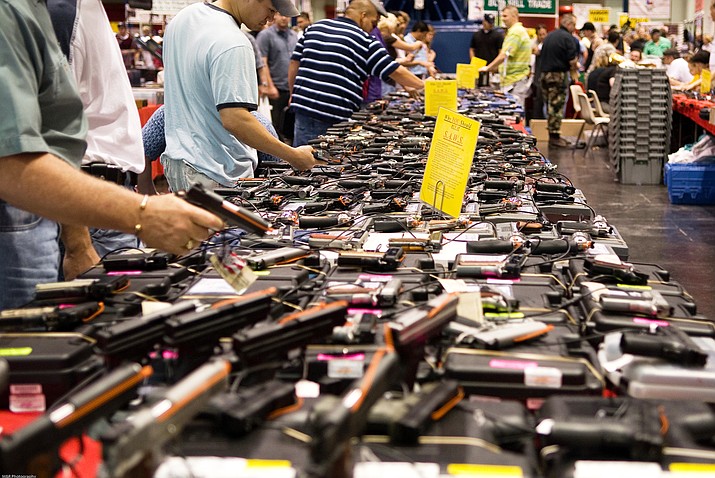 People shop at a gun show in Houston. Gun sales in Arizona and the nation rose steadily last year before dropping sharply at the first of the year, which experts attribute to the election outcome, before rebounding. (Photo by M&R Glasgow/Creative Commons)

