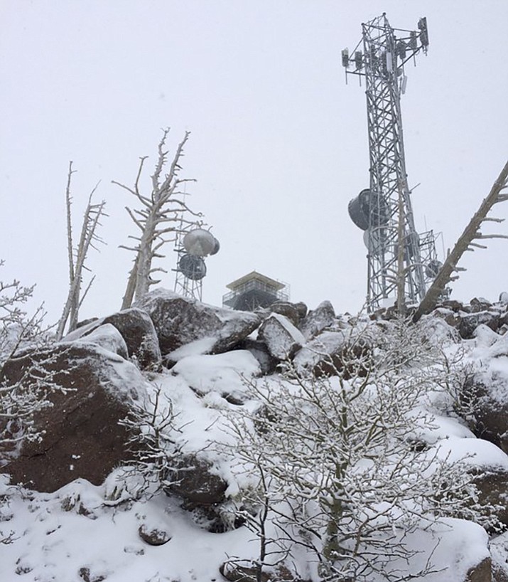 In this Tuesday, May 9, 2017 photo provided by Coconino County Sheriff shows a snow covered forest service lookout tower on Mt. Elden overlooking Flagstaff, Ariz. Authorities say a man had to be treated for hypothermia and rescued from the snowy northern Arizona mountain which he had hiked up while wearing only shorts and other light clothing in quest of free pizza. (Sgt. Aaron Dick/Coconino County Sheriff via AP)