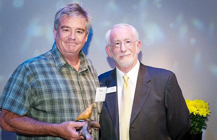 Cottonwood resident Bobby Woods, left, receives the Yavapai College Foundation’s Outstanding Volunteer Award for helping raise funds and awareness of the college’s programs in the Verde Valley. Presenting the award, Paul Kirchgraber, the foundation’s executive director. (Courtesy photo)