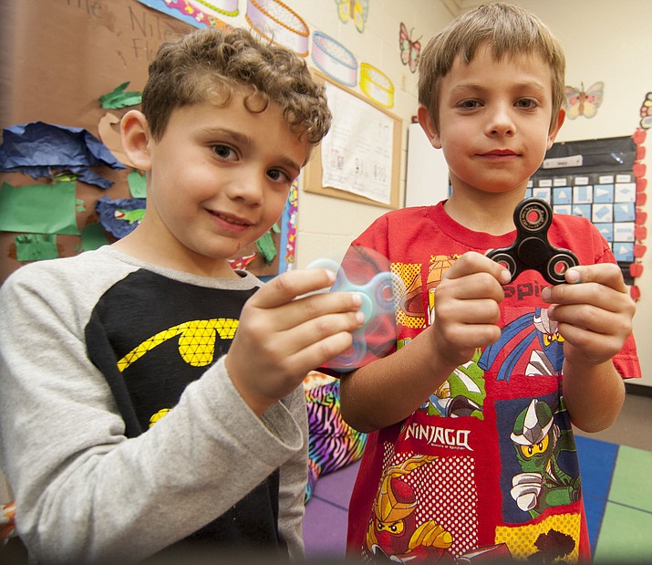 First-graders Kingston Morales, left, and Zachery Reynolds demonstrate their fidget 
spinners after school on Friday, May 19, in Prescott Valley.