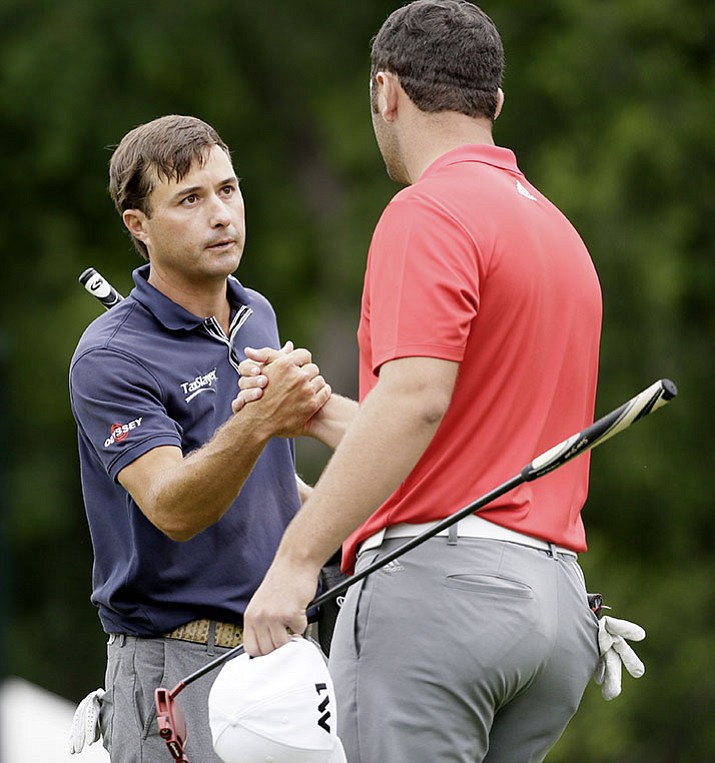 Kevin Kisner, left, shakes hands with Jon Rahm after playing the 18th hole during the the Dean & DeLuca Invitational golf tournament at Colonial Country Club in Fort Worth, Texas, Sunday, May 28. 