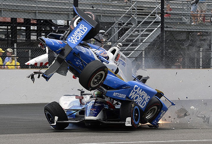 The car driven by Scott Dixon of New Zealand goes over the top of England’s Jay Howard in the first turn during the Indianapolis 500 on Sunday, May 28. Dixon started the race in the pole position.