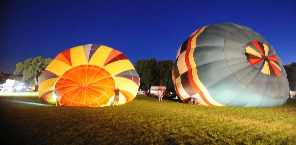Finally after the winds became more consistent the ballonists start the inflation process at the inaugural Arizona Craft Distillers Guild Festival and Balloon Glow Friday, June 9 on the football field at Prescott Mile High Middle School.  (Les Stukenberg/Courier)
