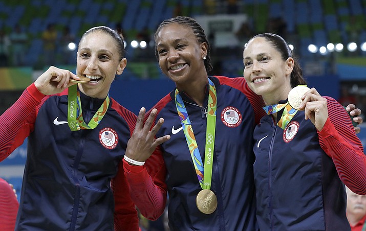 In this Aug. 20, 2016, file photo, United States' Diana Taurasi, left, Tamika Catchings, center, and Sue Bird, right, celebrate with their gold medals after their win in a women's basketball game against Spain at the 2016 Summer Olympics in Rio de Janeiro, Brazil. Taurasi and Bird, who won their fourth straight Olympic gold medals in Rio, are leaving the door open to continuing their U.S. careers. (Eric Gay/AP, File)