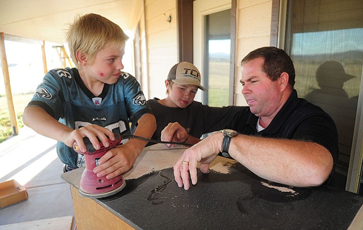 Shawn West with his sons, Andrew and Charles, at their Paulden home. (Les Stukenberg/Courier)