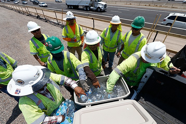 Crew members building the Loop 202 South Mountain Freeway take a break as they keep hydrated Tuesday, June 20, in Phoenix. (Ross D. Franklin/AP)