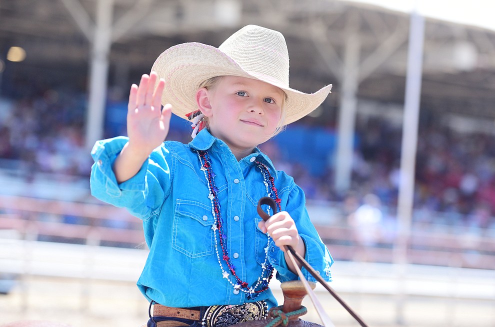 Kodi Kieckhefer waves to the crowd in the grand entry during the 8th and final performance of the Prescott Frontier Days Rodeo Tuesday, July 4 at the Prescott Rodeo Grounds.  (Les Stukenberg/Courier)