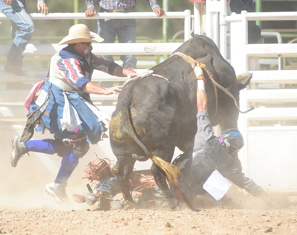 Bull fighters Luke Kraut and Quirt Hunt move in to save Kevin Salazar in the bull riding during the 8th and final performance of the Prescott Frontier Days Rodeo Tuesday, July 4 at the Prescott Rodeo Grounds.  (Les Stukenberg/Courier)