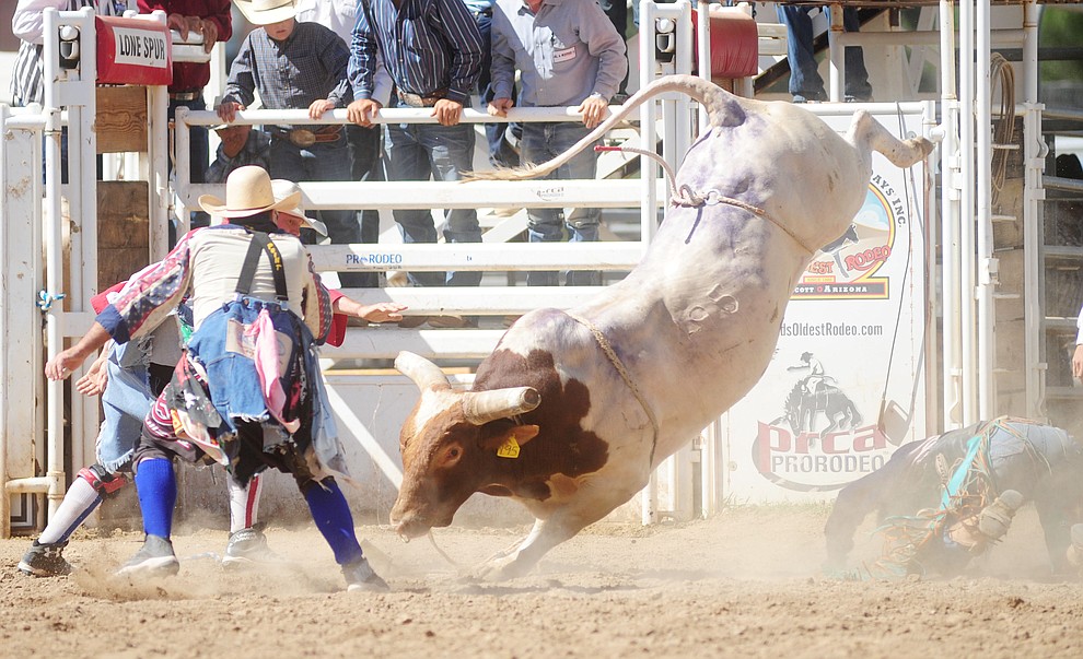 Bull fighters Luke Kraut and Quirt Hunt move in to distract the bull in the bull riding during the 8th and final performance of the Prescott Frontier Days Rodeo Tuesday, July 4 at the Prescott Rodeo Grounds.  (Les Stukenberg/Courier)