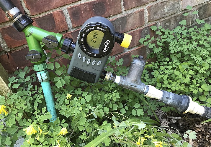 This June 26, 2017 photo shows the beginning portion of a drip irrigation system at a home in New Paltz, N.Y. Watering with drip irrigation has many benefits, not the least of which is that it is easily automated by merely setting a timer. The timer is pictured here along with the filter and pressure reducer that starts water off in any drip irrigation system. (Lee Reich via AP)