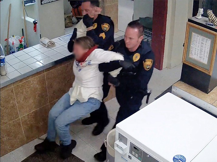 A woman who was reportedly being hostile and misusing washing machines is forcibly removed from a Prescott laundromat in December 2016. (Surveillance video screenshot)