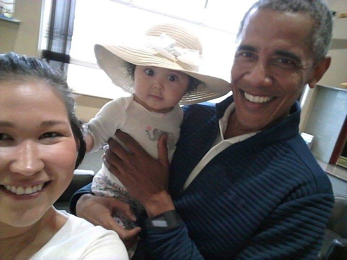 Former U.S. President Barack Obama holds Jolene Jackinsky’s 6-month-old baby girl while posing for a selfie with the pair at a waiting area on July 3 at Anchorage International Airport, in Anchorage, Alaska. Jackinsky said Obama walked up to her and asked, “Who is this pretty girl?” (Jolene Jackinsky via AP)

