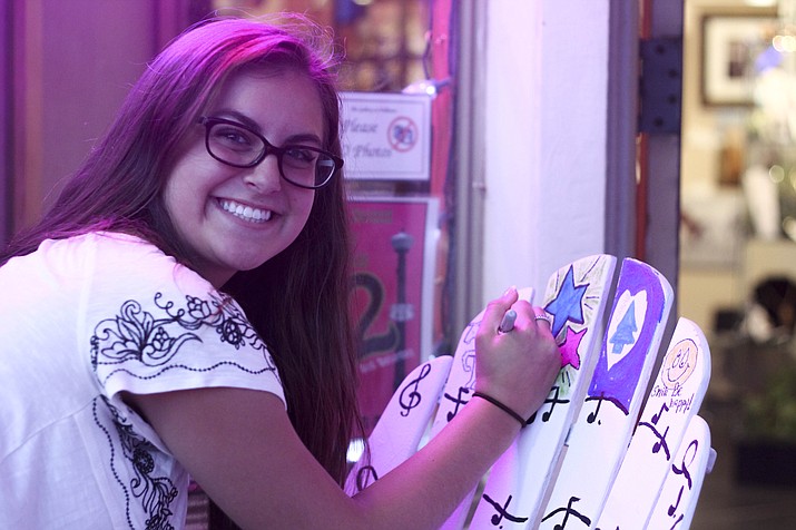 A young artist uses sharpies to decorate a chair during the Summer Artwalk in downtown Williams July 8. 