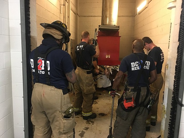 Emergency personnel respond to a call from a man who was stuck in a trash chute, early Sunday, July 23, 2017, in Washington. The man was throwing out trash at the apartment building when he thought he dropped a cellphone in the chute. When he leaned in to check he fell inside. (Vito Maggiolo/DC Fire and EMS Department via AP)


