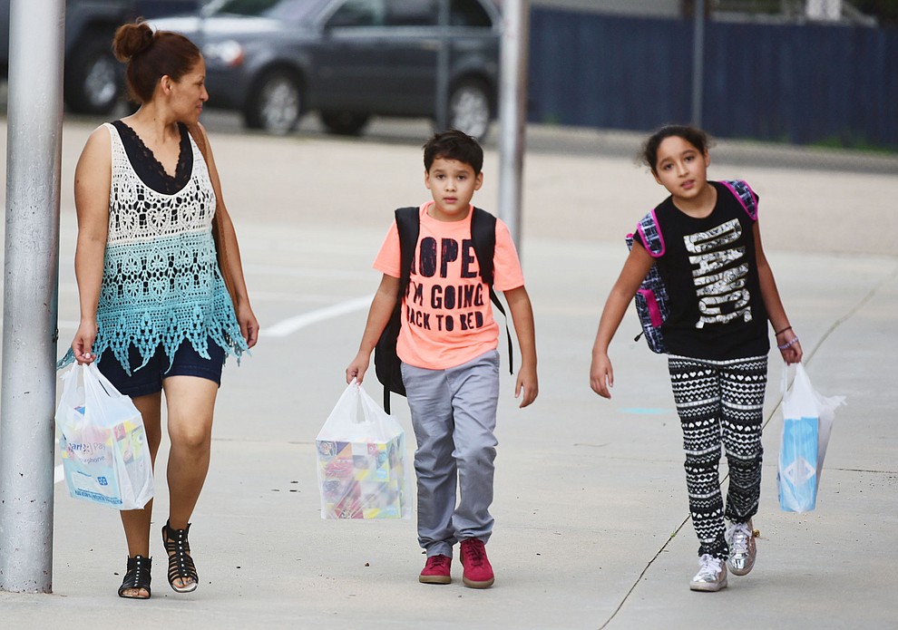 A family arrives with hands full at Lincoln School as students began the 2017-18 school year Thursday, August 2 in Prescott. (Les Stukenberg/Courier)