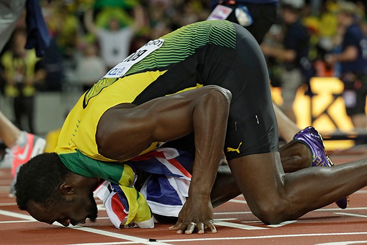 Jamaica’s Usain Bolt kisses the track after placing third in the men’s 100m final during the World Athletics Championships in London Saturday, Aug. 5. The race was reportedly the last of his career. (Matt Dunham/AP)