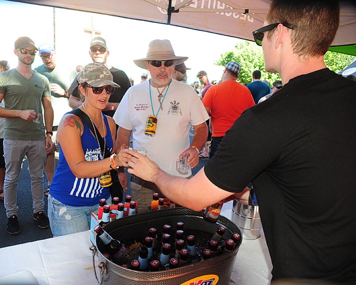 Nicole Garrett and Kevin Gordon get their Deschutes beers at the 4th annual Mile High Brewfest on Cortez Street in Prescott Saturday afternoon.