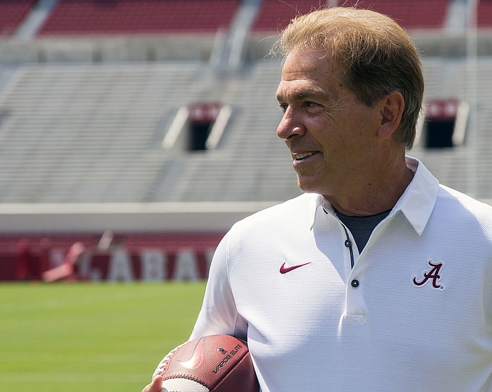 In this Aug. 5, 2017, file photo, Alabama head coach Nick Saban holds a football as he waits for the 2017 team picture before fan day in Tuscaloosa, Ala. (Vasha Hunt/AP, File)