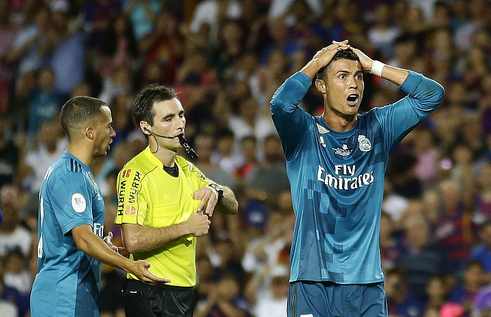 Real Madrid’s Cristiano Ronaldo, right, reacts after Referee Ricardo de Burgos shows a yellow card during the Spanish Supercup, first leg, soccer match between FC Barcelona and Real Madrid at the Camp Nou stadium in Barcelona, Spain, on Sunday, Aug. 13, 2017. (Manu Fernandez/AP)
