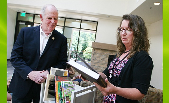 U.S. Congressman Tom O’Halleran (D-AZ) visits with Camp Verde Community Library Director Kathy Hellman as he donates 11 books Monday through the Library of Congress’s Surplus Book Program. (Photo by Bill Helm)
