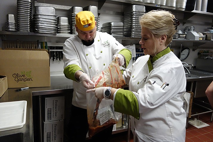 Olive Garden employees Tiffany Talbot and Seth Goldstein package unused soup to be donated to a local hunger relief organization. (Max Efrein/Courier)