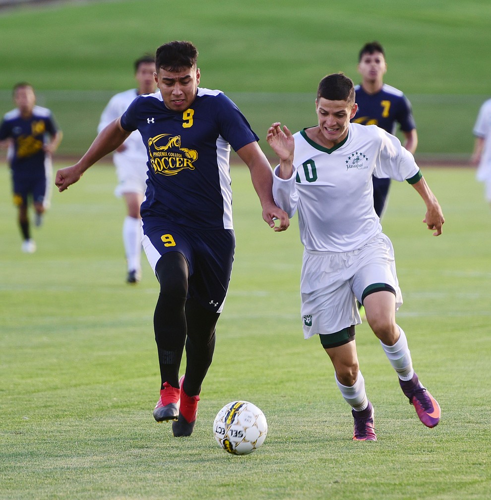 Yavapai's Carlo Quesada battles for the ball with Noe Ancira as the Roughriders take on the Phoenix College Bears Tuesday night at Mountain Valley Park in Prescott Valley. (Les Stukenberg/Courier).
