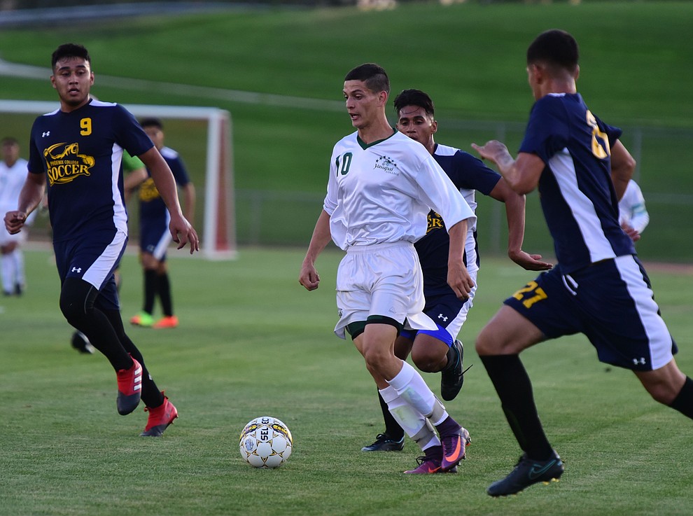 Yavapai's Carlo Quesada moves the ball through a trio of defenders as the Roughriders take on the Phoenix College Bears Tuesday night at Mountain Valley Park in Prescott Valley. (Les Stukenberg/Courier).