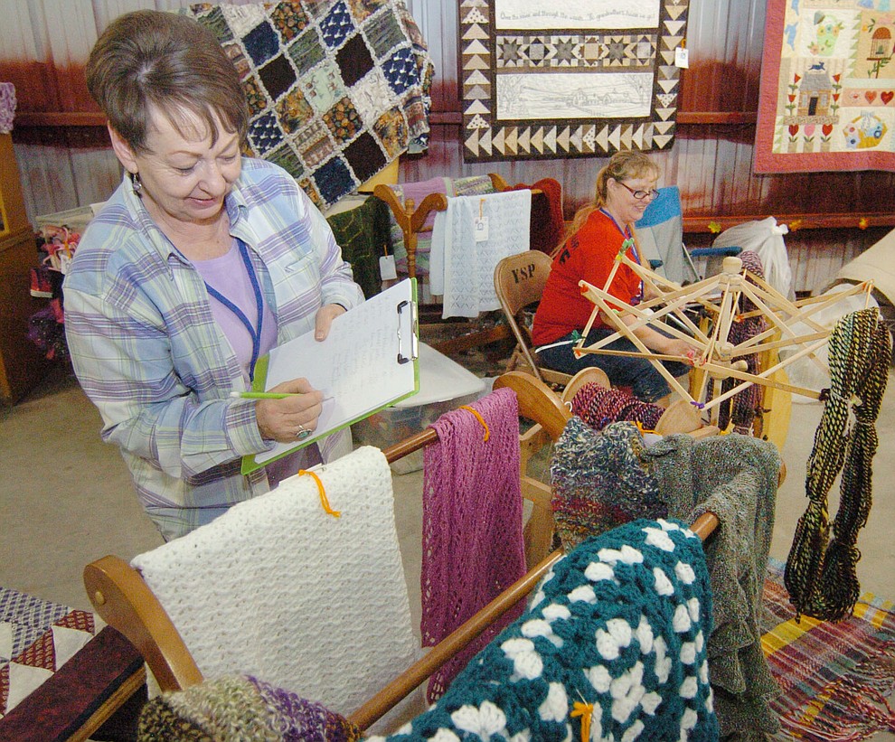 Carma Koester writes down the list of winners in homemaking arts as Melissa Lee spins in the background at the 2017 Yavapai County Fair at the Prescott Rodeo Grounds Wednesday, September 7 in Prescott . (Les Stukenberg/Courier).