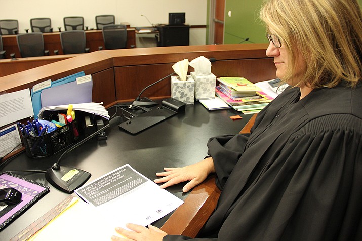 Yavapai County Superior Court Judge Anna Young examines a recently released bench card by the National Council of Juvenile and Family Court Judges. (Max Efrein/Courier)