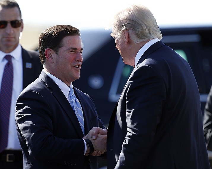 President Donald Trump greets Arizona Gov. Doug Ducey, left, after stepping off Air Force One as he arrives Tuesday, Aug. 22, 2017, in Phoenix. (Alex Brandon/ AP Photo)