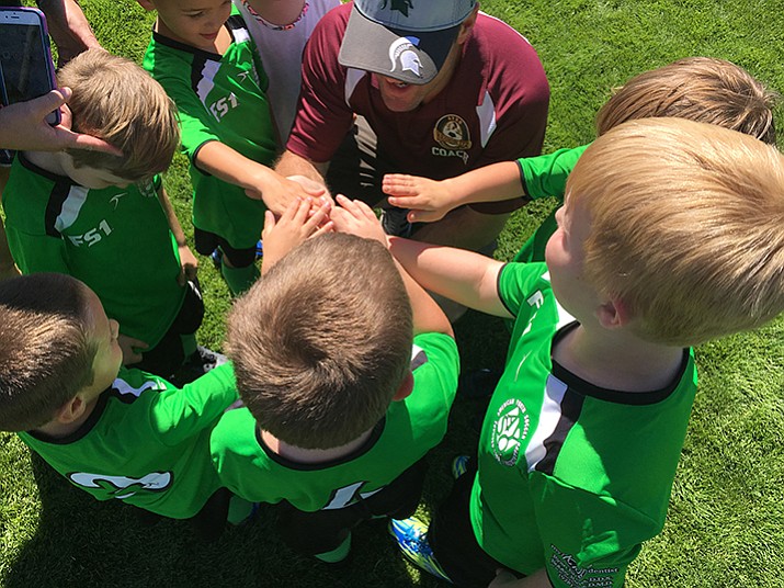 Prescott’s AYSO 6U club, The Green Ninjas, get together for a team cheer after their first game Saturday, Sept. 16, in Prescott. (Brian M. Bergner Jr./Courier)