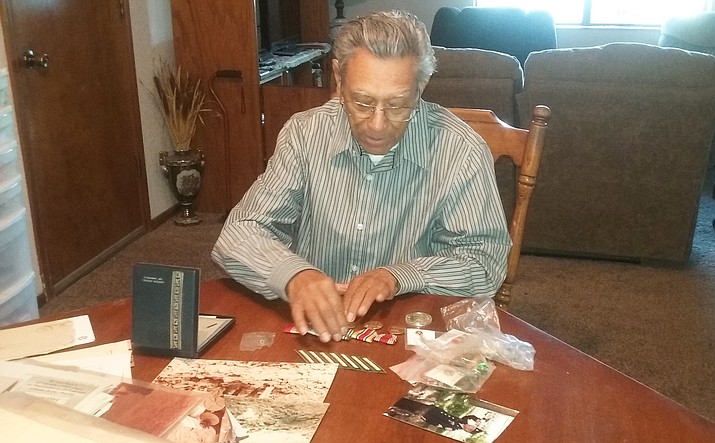 Korean War Veteran Angel Vargas looks at old photos and memorabilia from his time in the service. The local resident has been invited to the nation’s capital to be honored. (VVN/ Gianina Lomedico)