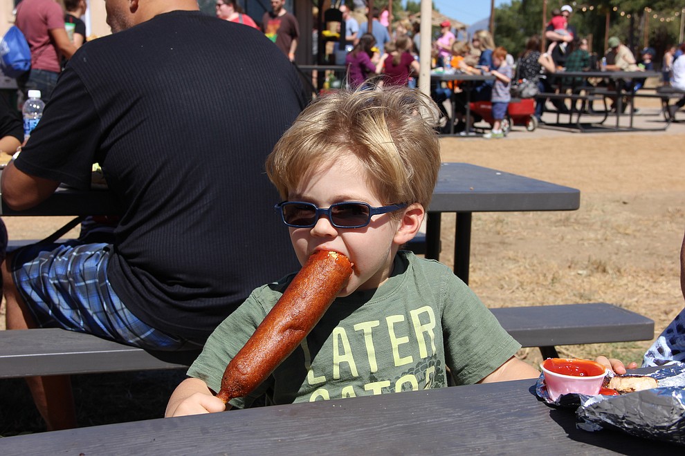 Benjamin Sassenberg bravely takes on a foot-long corn dog at the festival on Saturday, Sept. 30. (Max Efrein/Courier)